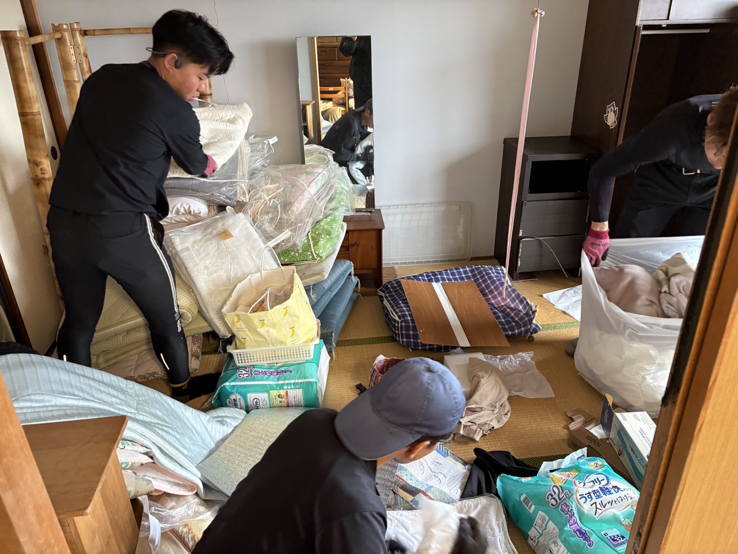 実家に残った家財をスタッフが仕分けしている作業写真