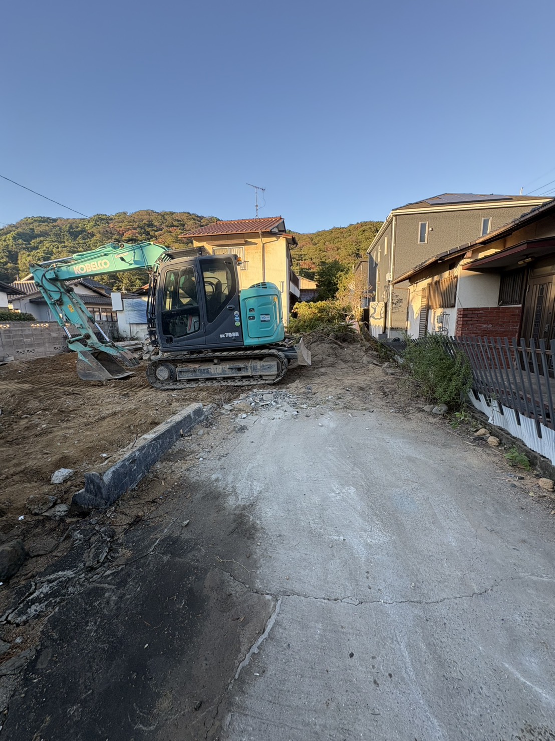 隣家との距離を確保しながら重機を使用している岡山市東区赤田の解体現場