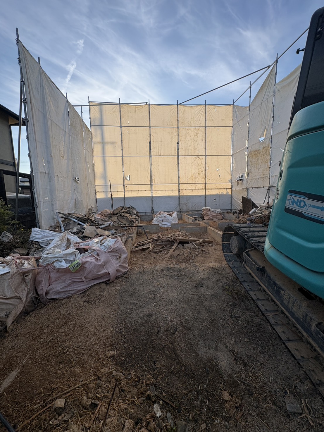 建物解体後に残った基礎と地面まわりを撤去している状態